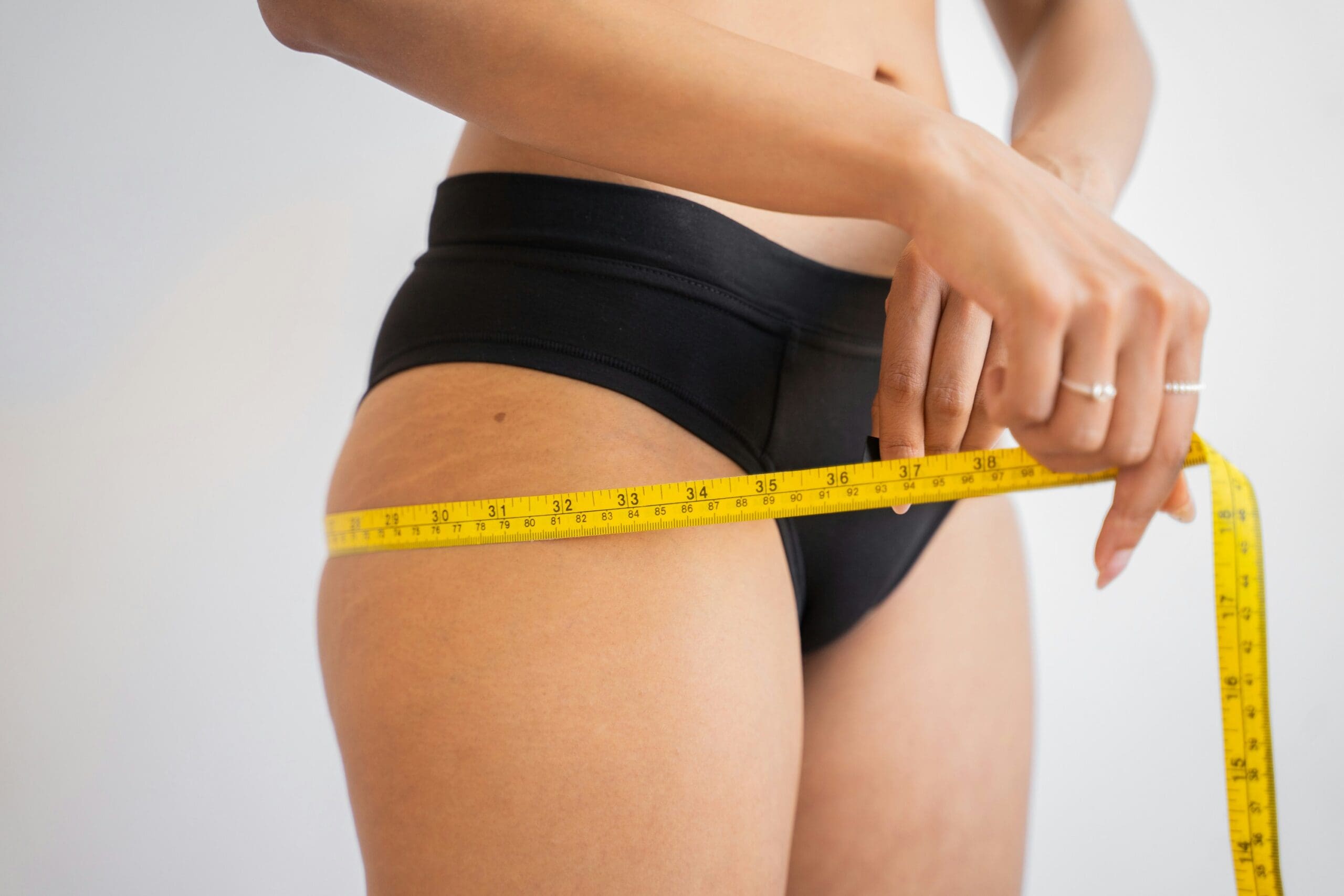 Woman measuring her hips as part of a hormone-supported weight loss journey after 40