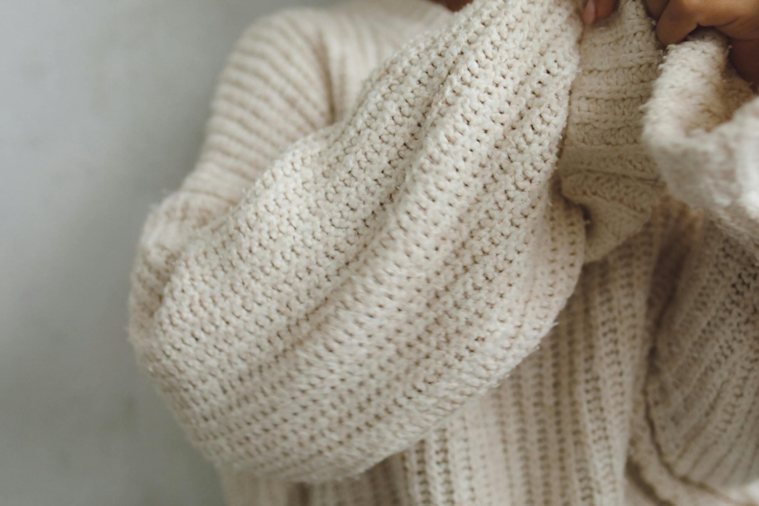 Close-up of a woman in a beige sweater smiling outdoors, representing winter wellness and women’s health