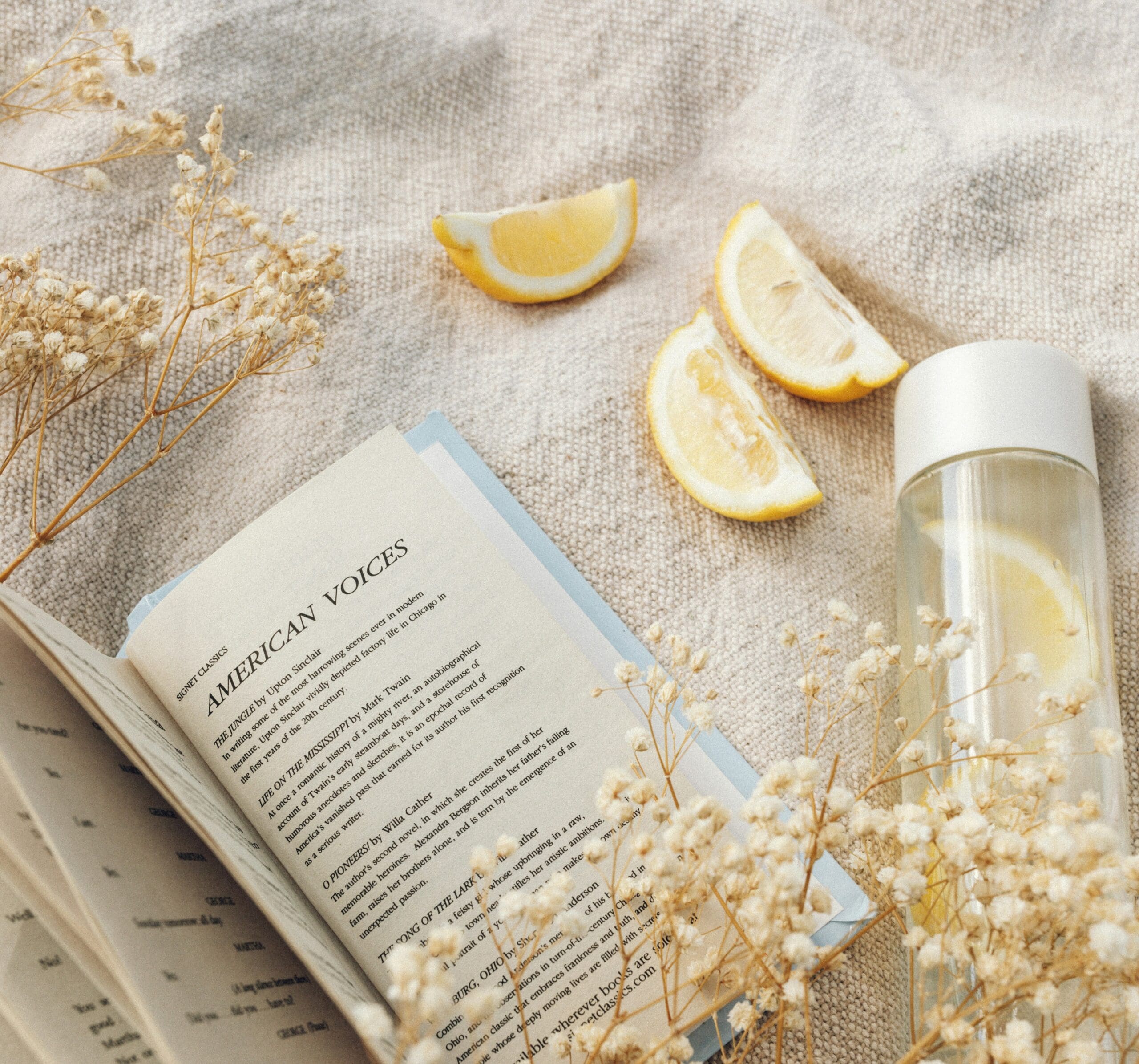 Wellness flat lay with lemon water, book, and natural elements representing peptide therapy for hormone health and cellular wellness at Wellness & Hormone Health in Centennial CO