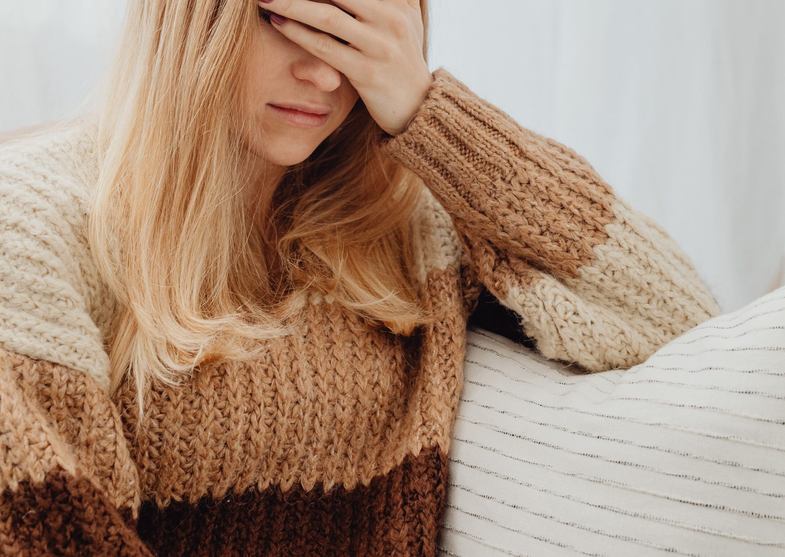 Woman holding her head, representing mental health changes and emotional symptoms during perimenopause.